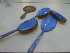 A very pretty blue enamel and silver dressing table set comprising three brushes and a hand mirror A