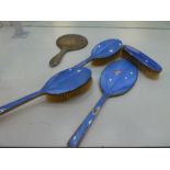 A very pretty blue enamel and silver dressing table set comprising three brushes and a hand mirror A