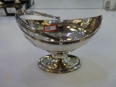A Georgian Silver bon bon dish on a pedestal foot with a handle. Appears to be of very high quality.