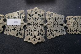 An antique silver plated belt made up of 15 pierced sections