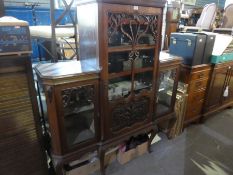 An antique mahogany sideboard having scroll decoration and three glazed doors