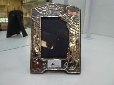 A silver photo frame with a Golfer and design on low relief, hallmarked London 1987 John Bull Ltd, 2