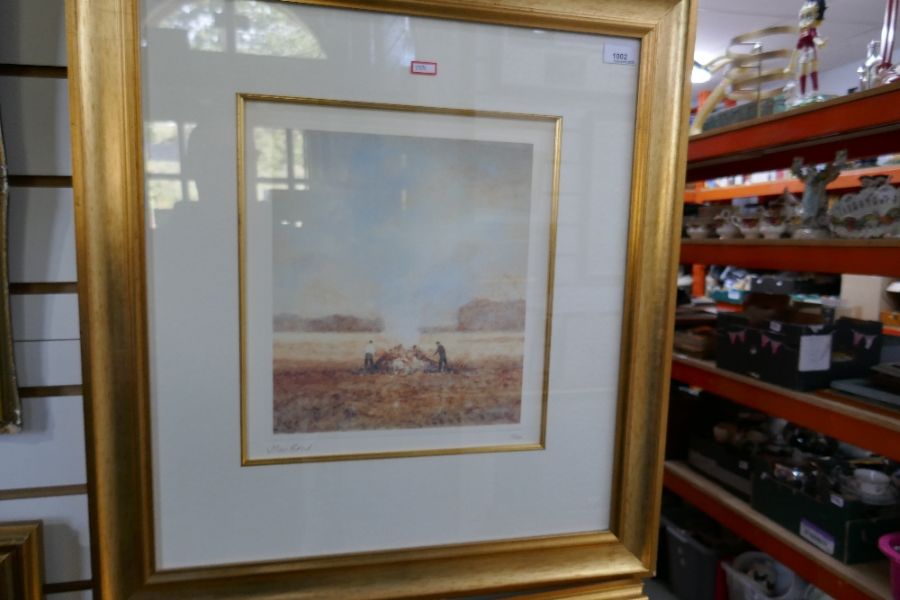 A pair of gilt framed and glazed pencil signed limited edition prints depicting farmers in fields si
