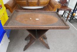 An old Burmese carved oblong tray on folding base, 74.5cm