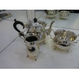 A high quality silver three piece tea service comprising of a teapot with ebonized wood handle and k