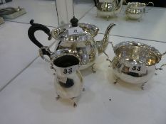 A high quality silver three piece tea service comprising of a teapot with ebonized wood handle and k