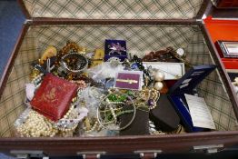 A vintage leather case containing vintage costume jewellery to include necklaces, pearls, brooches,