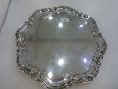 A large heavy silver salver of circular form on four feet. Hallmarked Sheffield 1925 AHein Brothers.