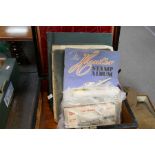 An antique rosewood box containing postcards, stamps and similar