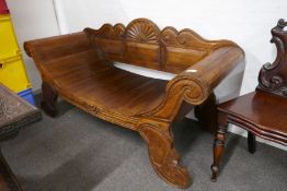 A modern Indonesian teak bench having scroll ends and carved decoration