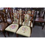 A set of four dining chairs having tapestry floral seats and backs
