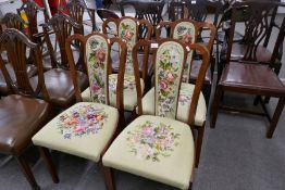 A set of four dining chairs having tapestry floral seats and backs