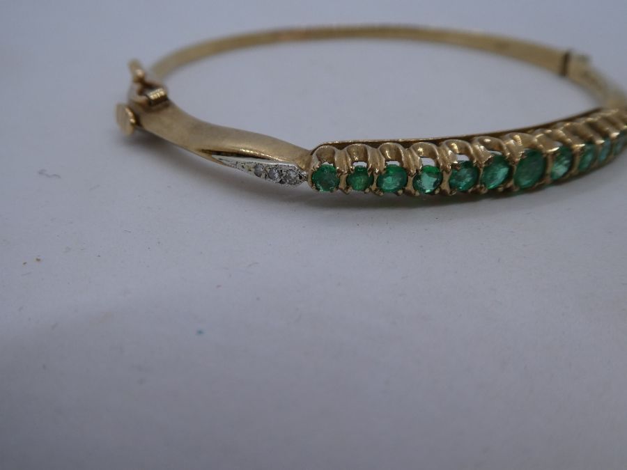 A 20th century 9ct yellow gold emerald and diamond hinged bangle comprising of thirteen round cut em - Image 3 of 5
