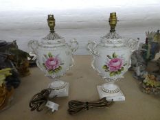 A pair of Royal Worcester table lamps in the form of 2 handled urns, with floral and gilt decoration