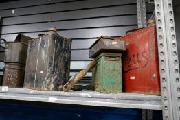 Shelf of various vintage oil cans, tins, oil tunnels & pumps