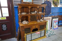 A quality oak dresser with open shelf above central glazed door over waist draw and kennel, flanked