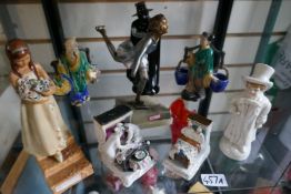 A shelf containing porcelain figures to include Worcester, Chinese and Wade examples and skating Lad