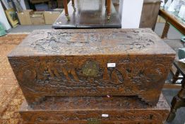 A camphor wood blanket box heavily carved with oriental decoration depicting ships and birds