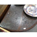 An antique mahogany drop leaf oval table with later floral carvings