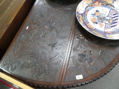 An antique mahogany drop leaf oval table with later floral carvings