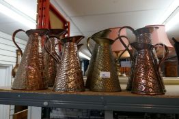 A selection of various vintage brass and copper water jugs some with maker's stamps and logos to the