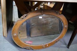 A vintage oak framed oval bevelled wall mirror, with beaded decoration, 87cm