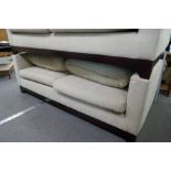 A modern 2 seat sofa upholstered in cream fabric