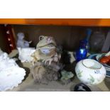 A large pottery pond fountain in form of a frog sitting on a log