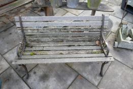 Vintage weathered teak garden bench on cart iron ends