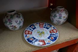 A trio of Oriental porcelain comprising of a pair of ginger jars and a plate decorated with yellow a