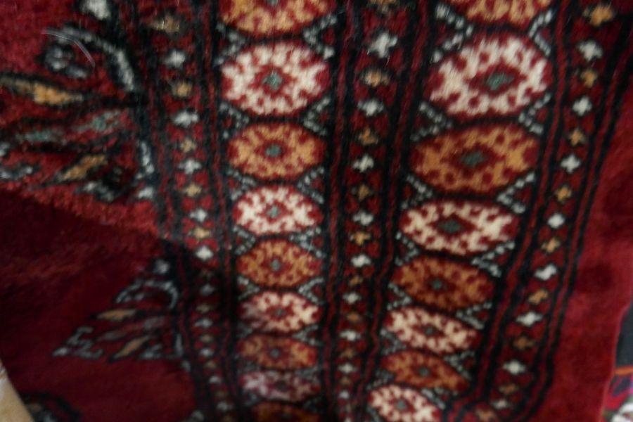 A middle eastern red ground carpet with elephant pad decoration and border
