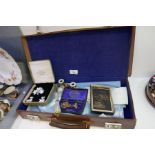 Vintage leather case containing Masonic items, including aprons, medals, Mother of Pearl opera binoc