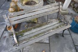 Vintage weathered teak garden bench with decorated wrought iron arms