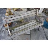 Vintage weathered teak garden bench with decorated wrought iron arms