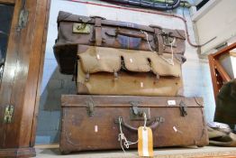 A selection of vintage leather suitcases, mailbag and camping bag