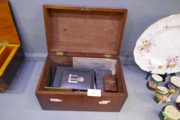 A vintage box containing assorted items, including a Dunhill lighter, a seal, a spirit flask, etc