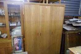 A contemporary oak three door wardrobe and a pair of matching bedside chests and a 6 drawer chest