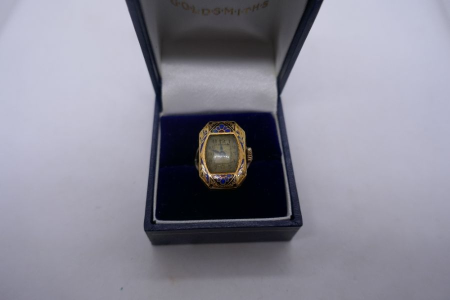 Unusual 9ct yellow gold ring mounted with an 18ct yellow gold and enamelled watch, marked .75, 18. 6