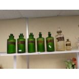 Five old green glass poison bottles and two others