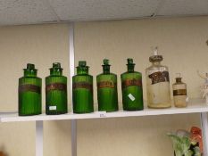 Five old green glass poison bottles and two others