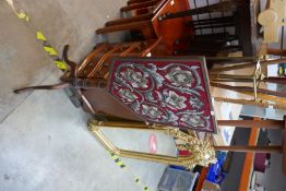 An adjustable firescreen on tripod stand, shield shaped tapestry