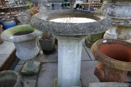 A large bird bath on associated square pillar