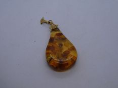 Yellow metal pendant hung with pear shaped amber stone