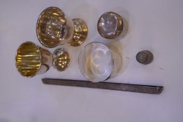 A silver gilt egg cup with another silver egg cup, a silver thimble, silver napkin ring and silver t