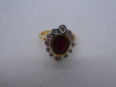 Pretty 18ct yellow gold cocktail ring with central oval ruby surrounded by 12 round cut diamonds, ma