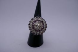 Impressive unmarked white metal, tested as 18ct diamond and ruby cluster ring comprising central clu