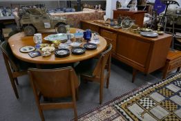 1970s teak sideboard having 3 central drawers, a similar dining table with a folding leaf and set of