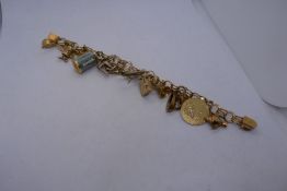 Rolled gold charm bracelet hung with approx 7 gold charms to include grammaphone, sewing machine, ir