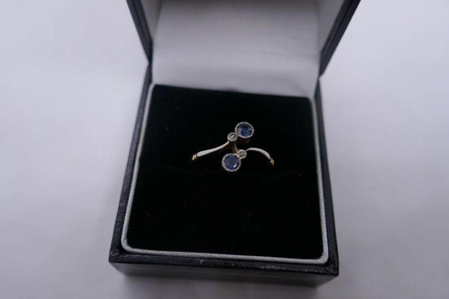 18ct two tone crossover design ring inset with two pale blue sapphires and two small diamonds, marke - Image 3 of 4