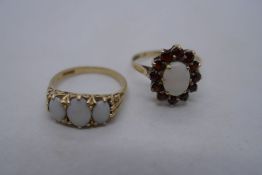 9ct yellow gold cluster ring with central oval white opal surrounding by garnet, marked 375, size N